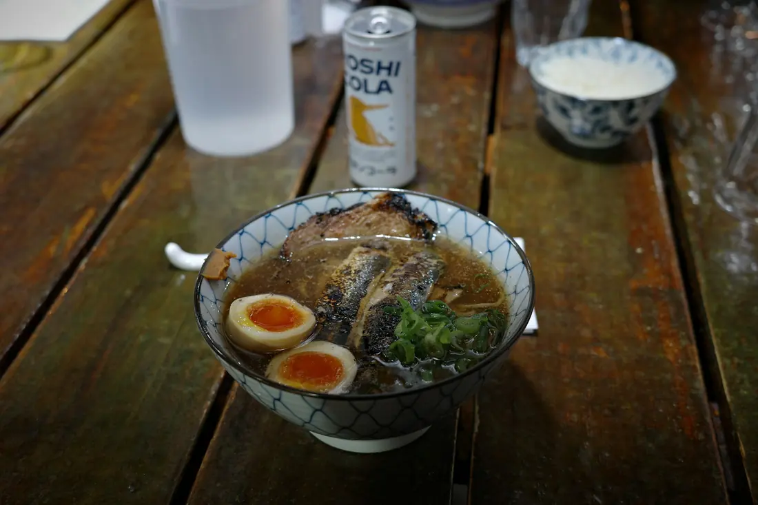 A ramen bowl topped with pork, a soft egg and nori