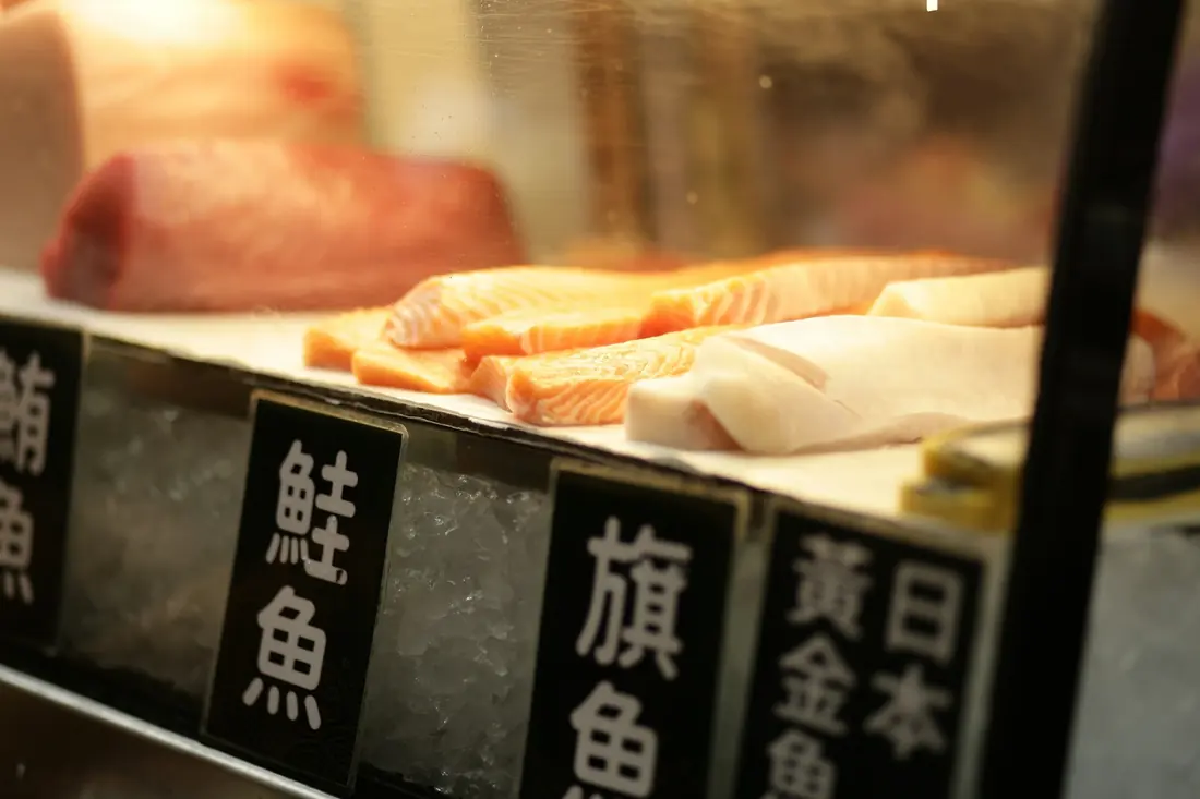 Fish fillets laid out on ice at a market counter