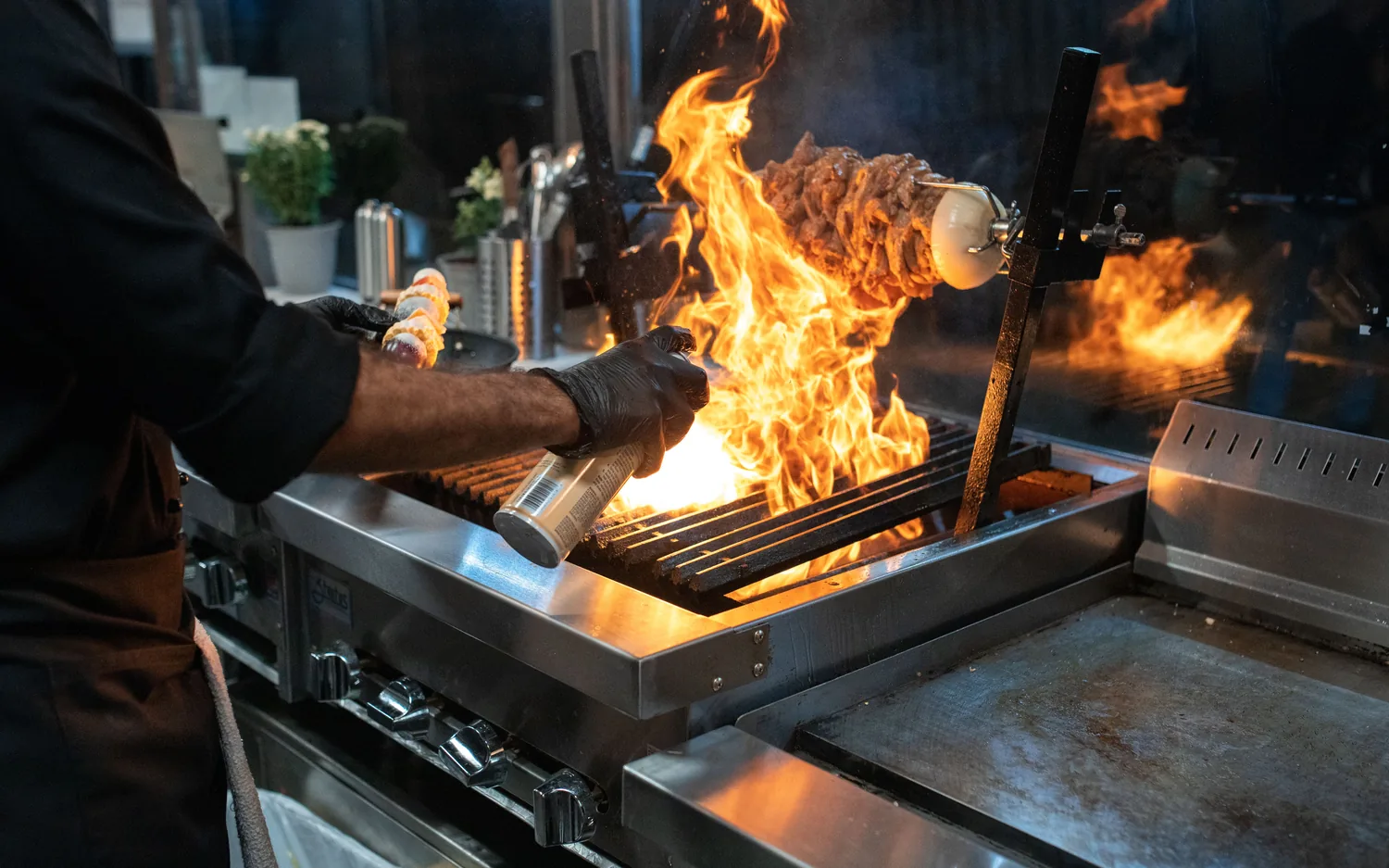 A cook searing food on a flat top grill