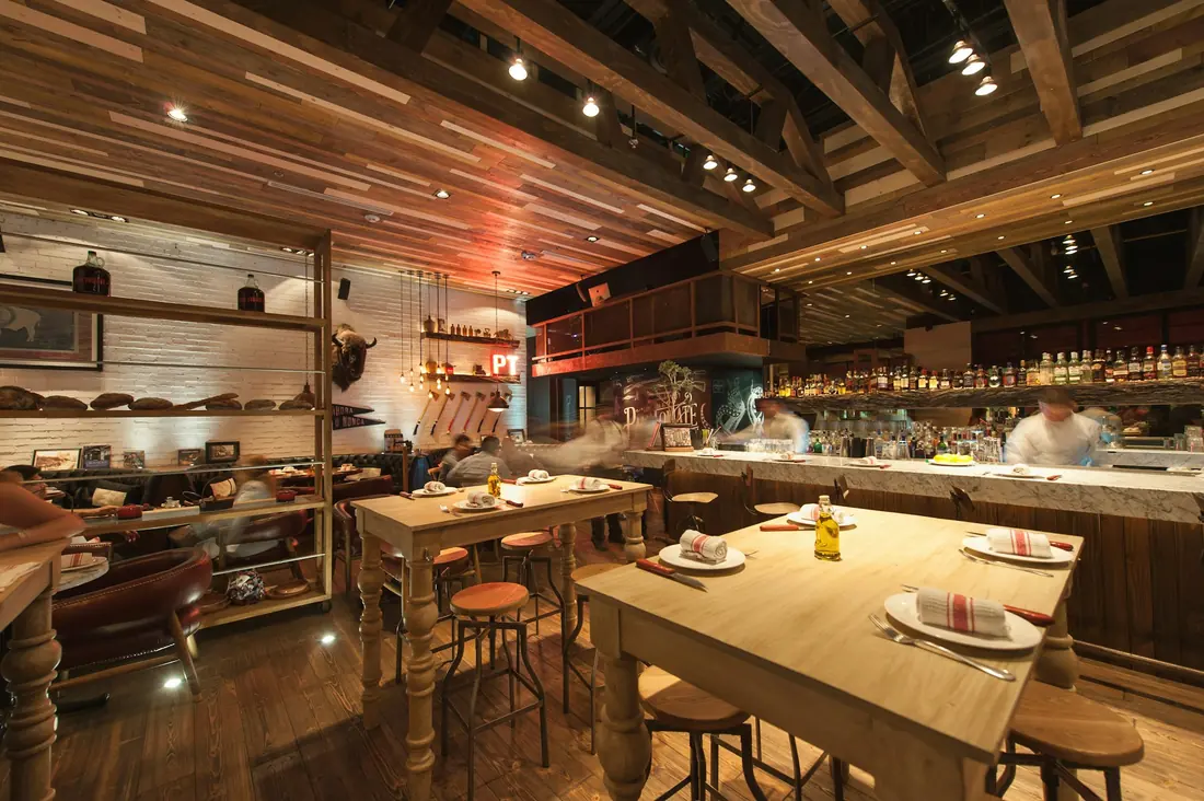 Warmly lit tables inside a casual Japanese restaurant dining room