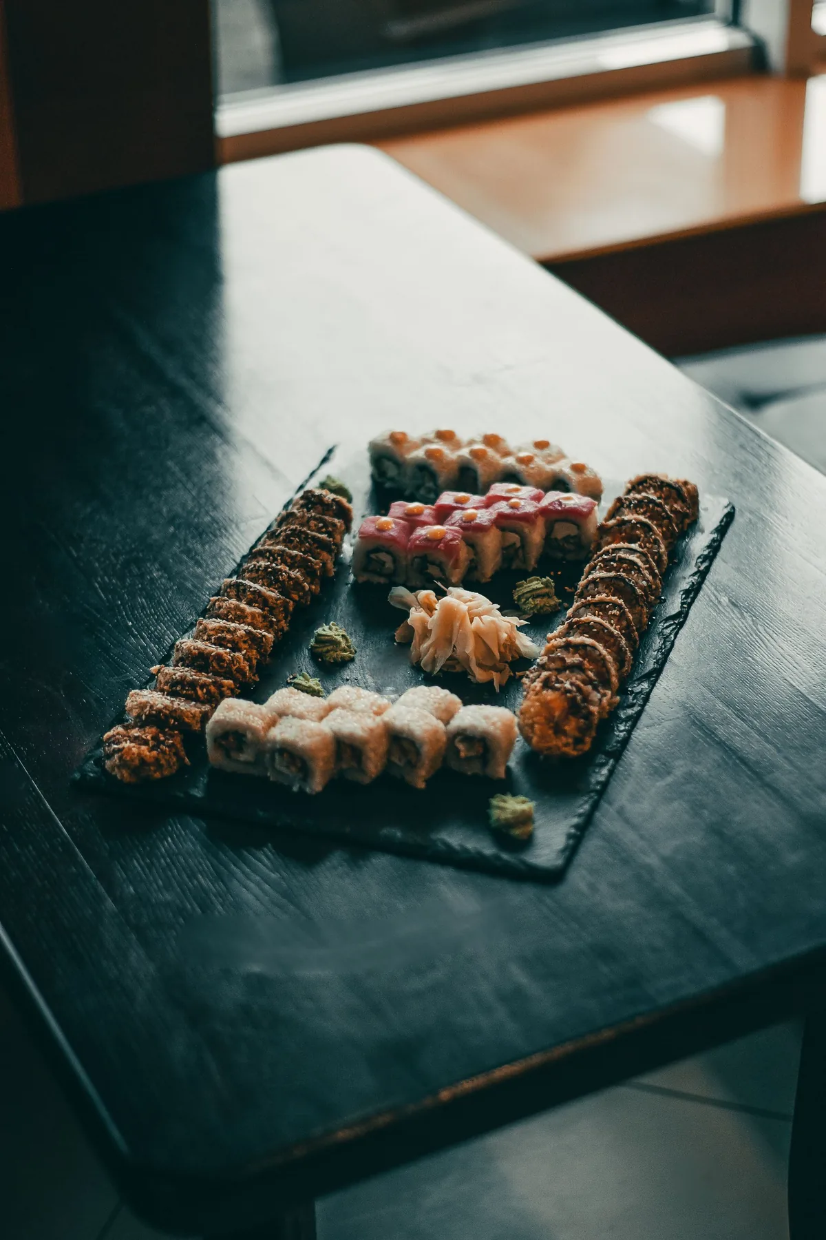 An assortment of specialty rolls arranged on a slate board