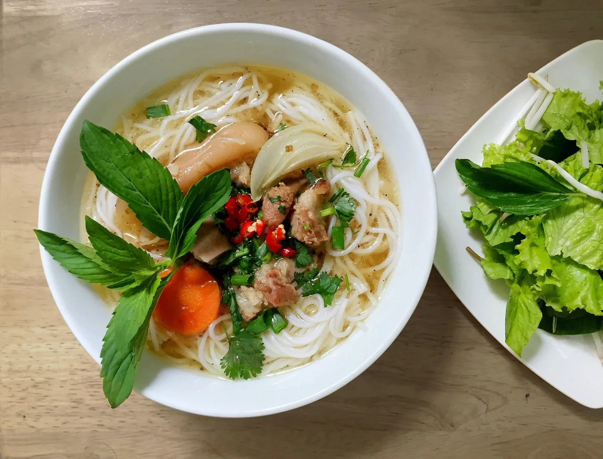 Bowl of pho noodle soup with rice noodles, herbs and broth
