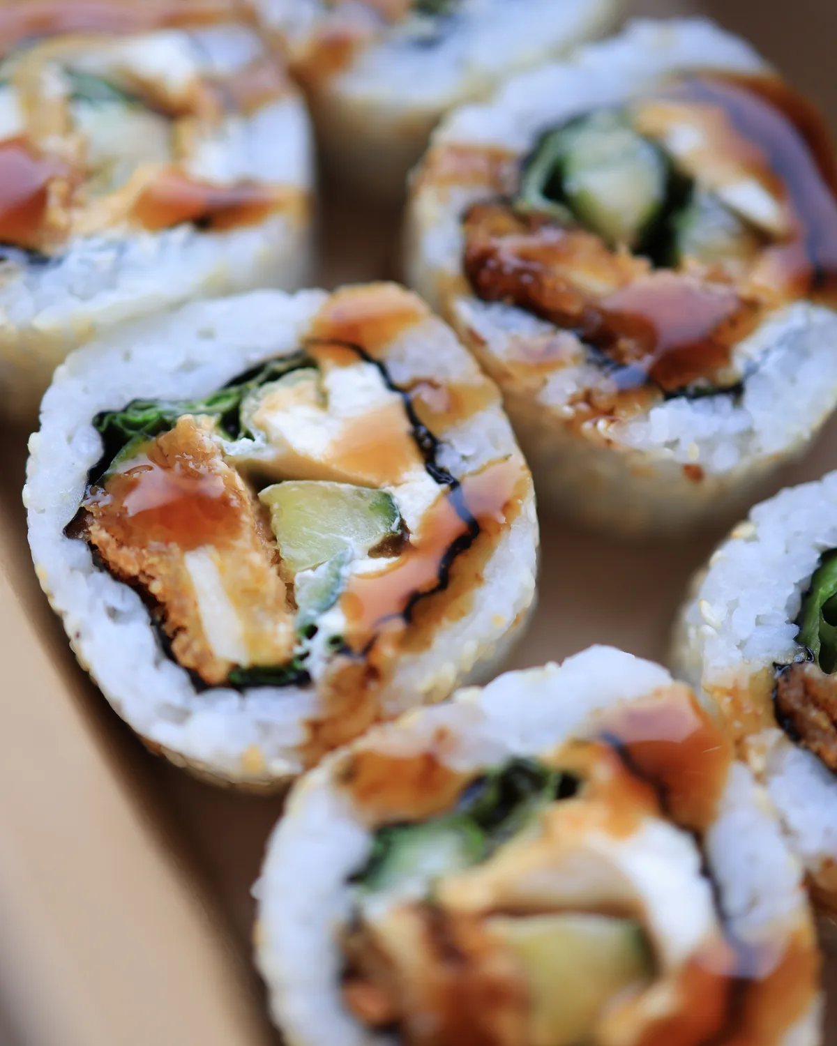 Close-up of a sliced sushi roll with tempura and avocado