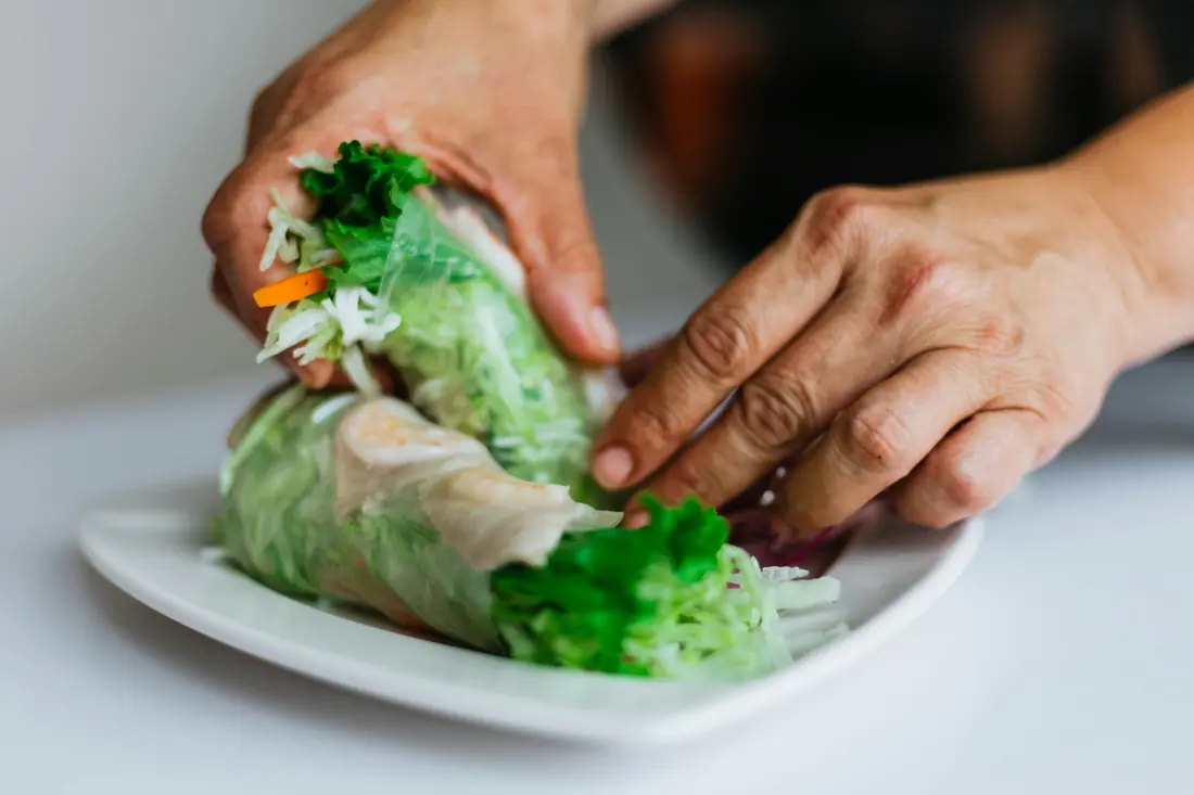 A vegetable filling being rolled into a wrapper