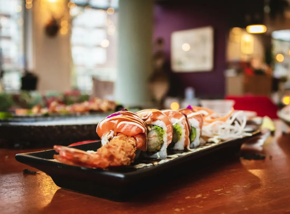 A crispy shrimp tempura roll on a dark plate