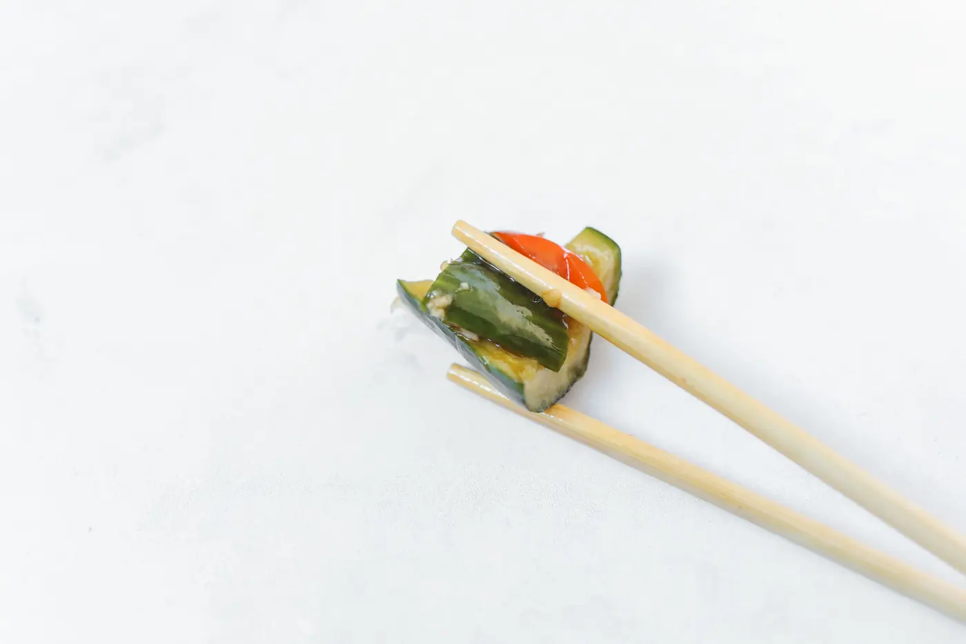 Pickled vegetable slices held in chopsticks