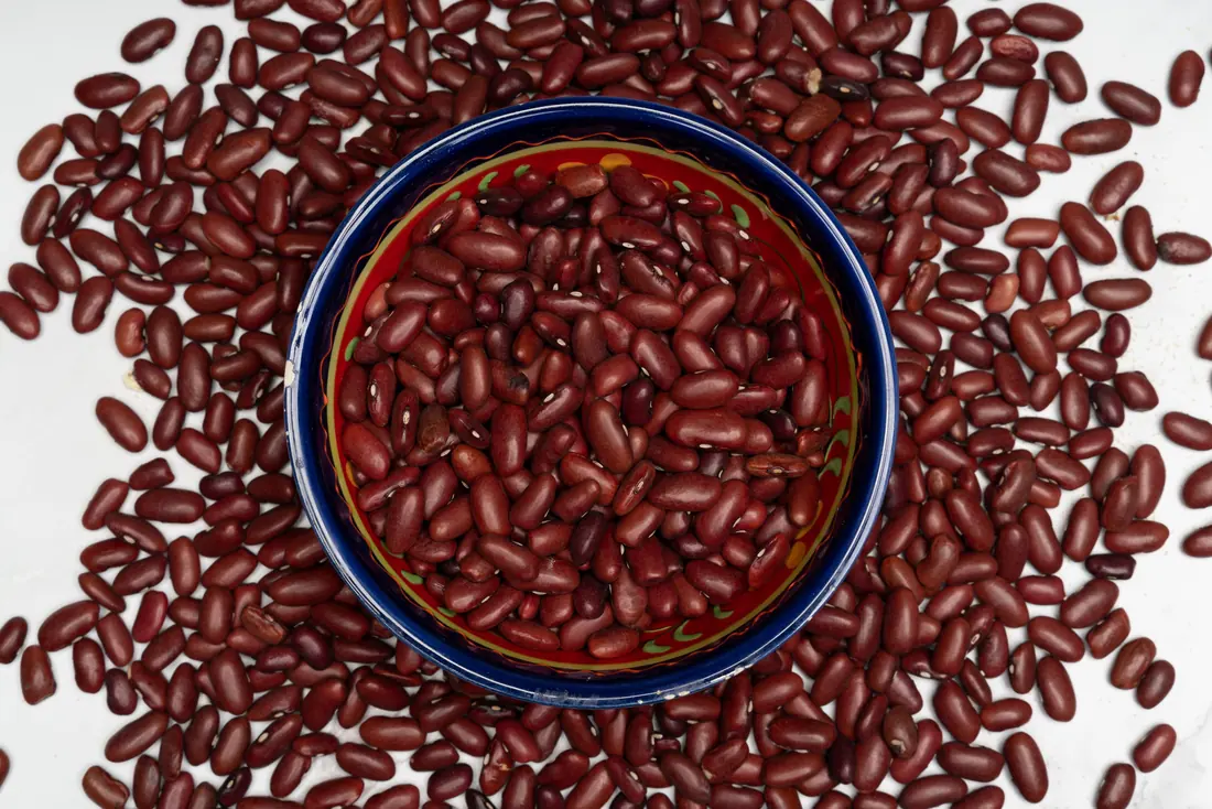 Dried red beans around a bowl