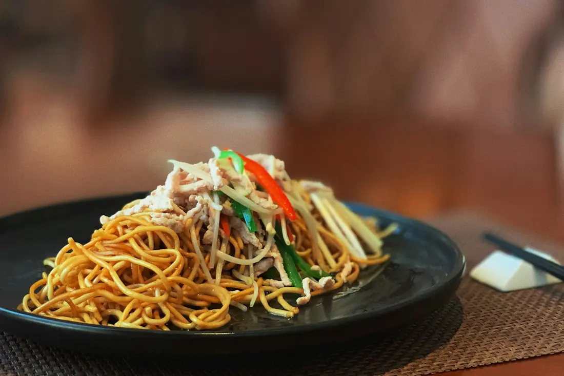 Soft egg noodles coated in a dark sauce