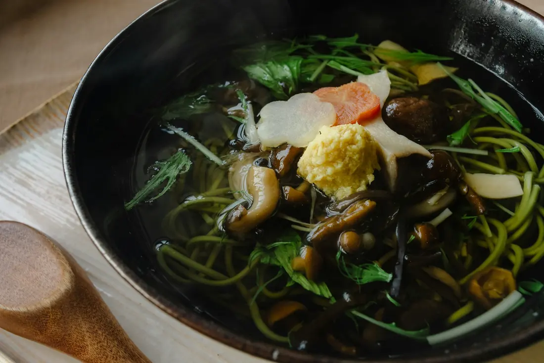 A dark broth with seaweed and vegetables
