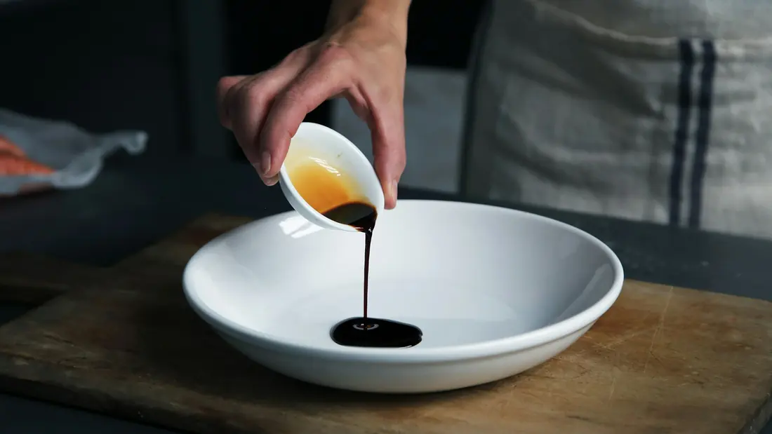Soy sauce being poured into a shallow dipping dish