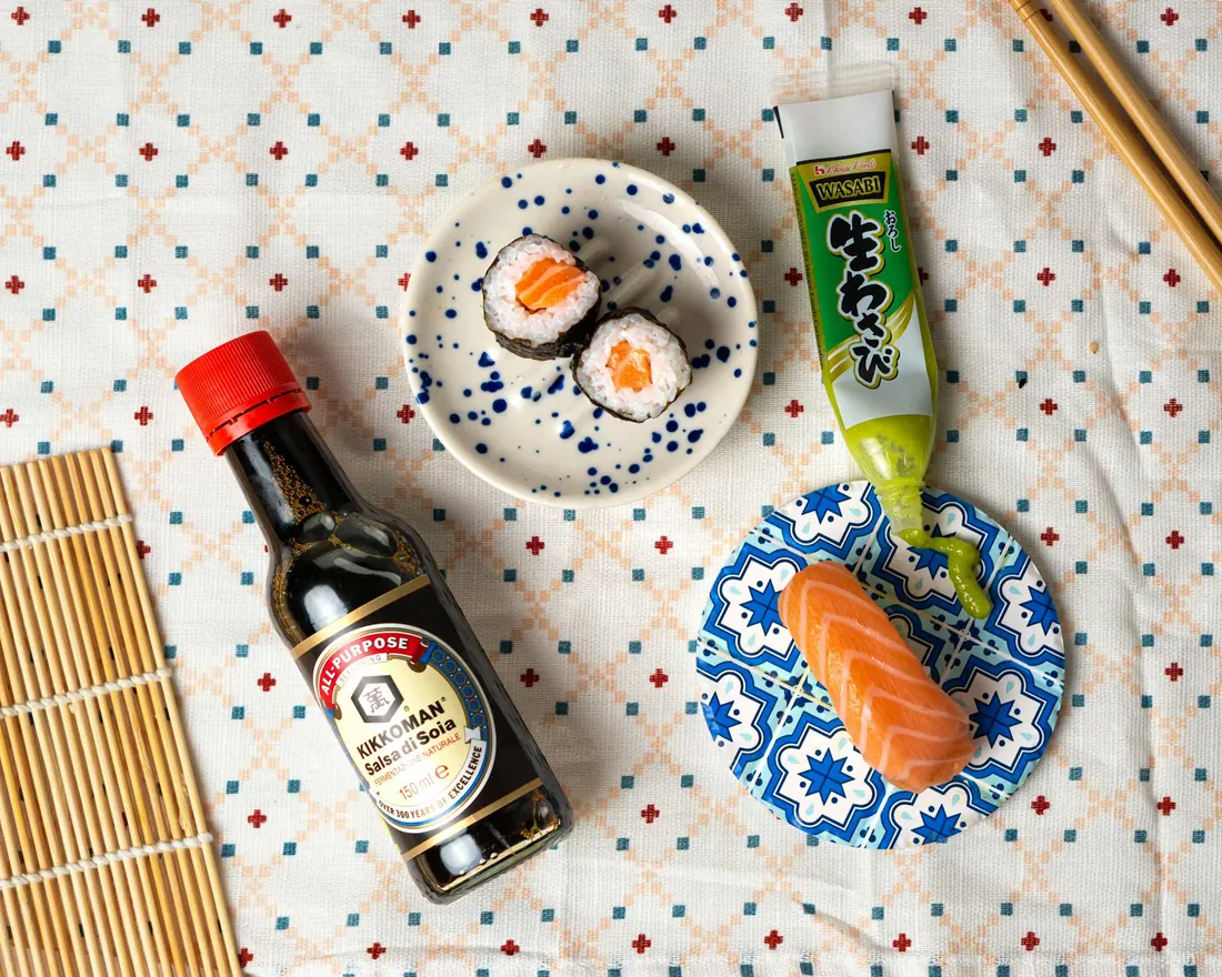 Soy sauce, wasabi and pickled ginger set beside a sushi plate