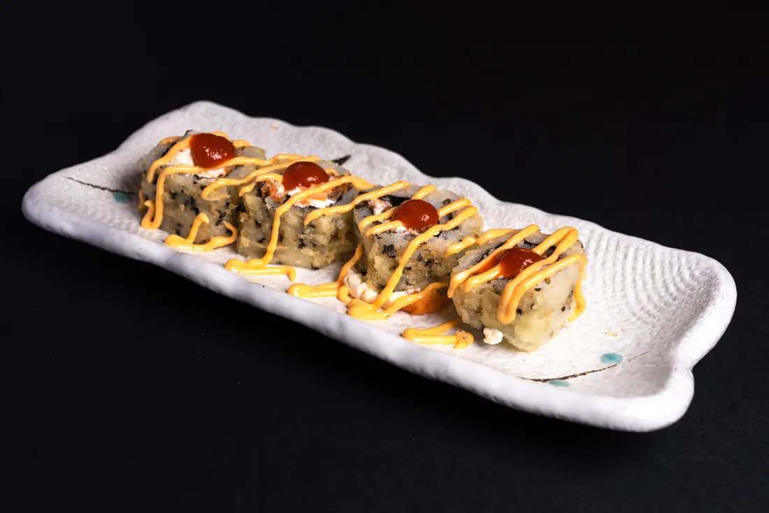 A spicy tuna roll finished with a chilli sauce drizzle