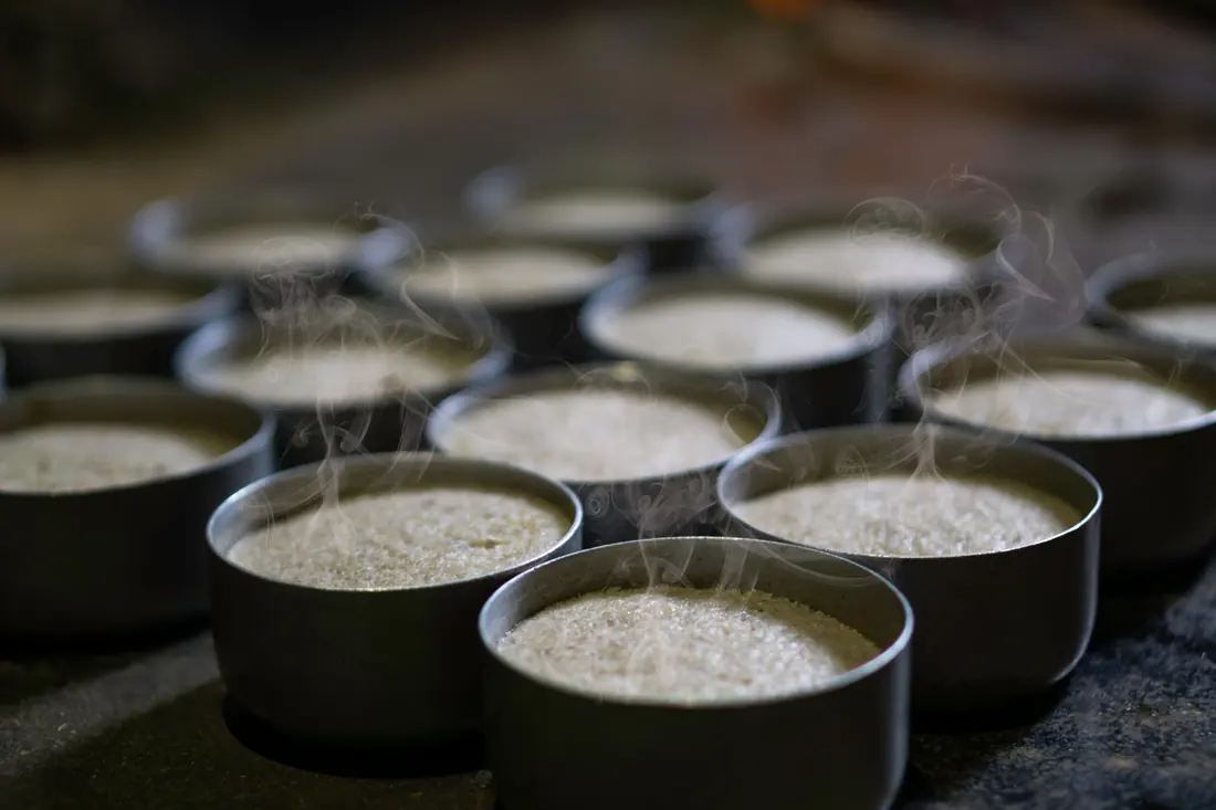 Steam rising from bowls of freshly cooked rice