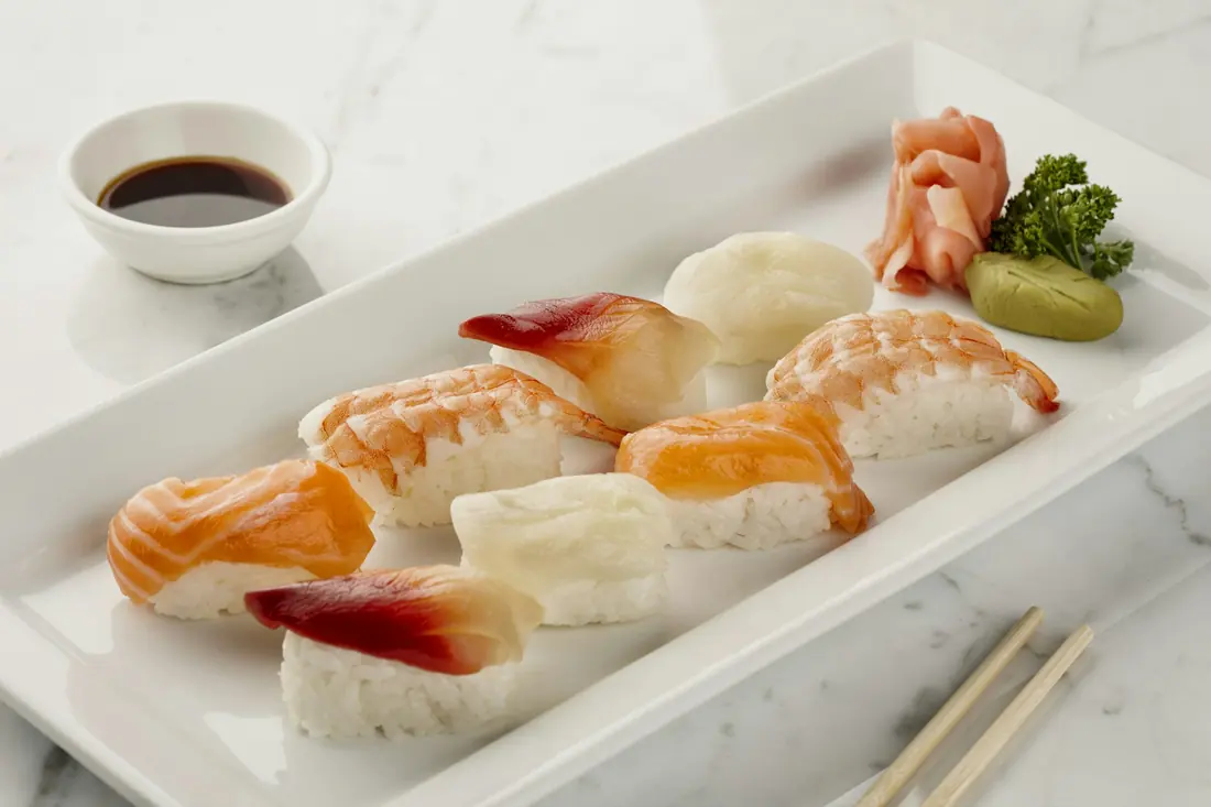 Finishing sauce being drizzled across a plated roll