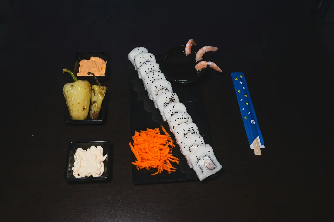 A cut sushi roll laid out with pickled ginger and accompaniments