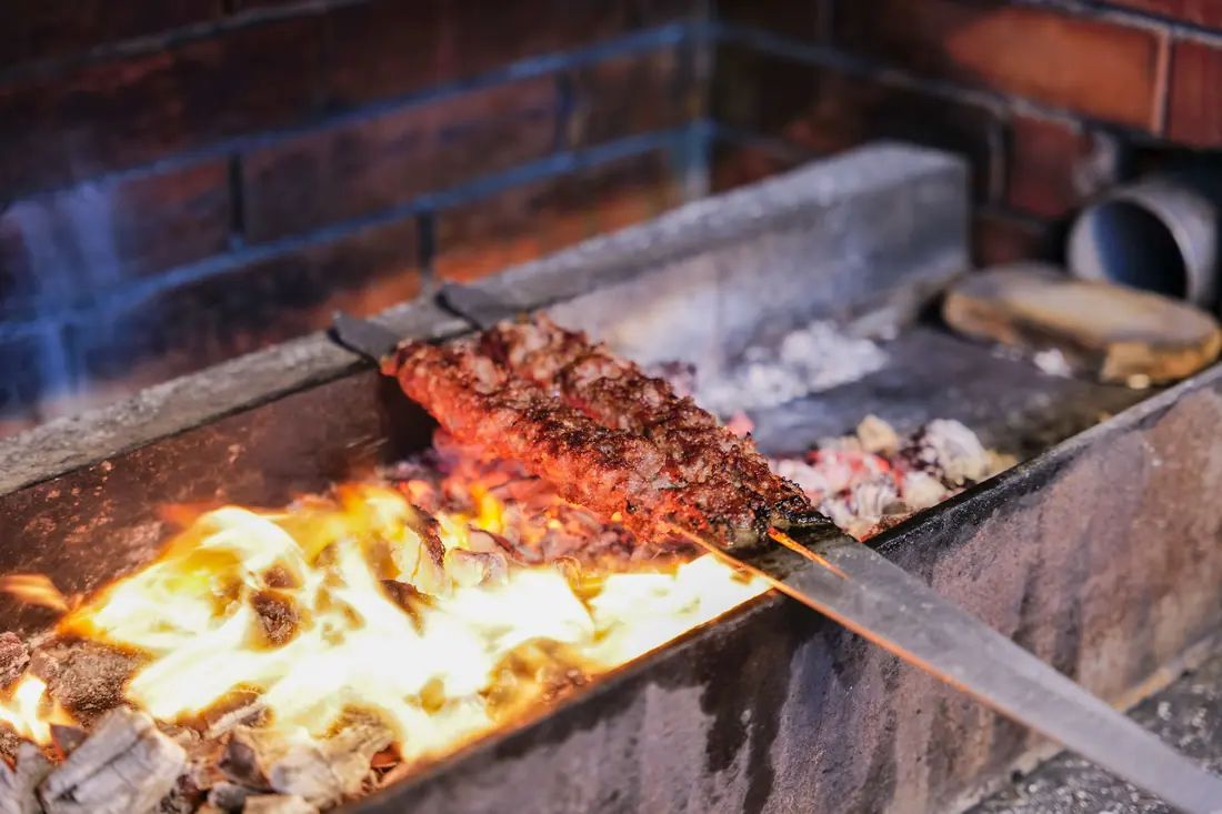 Skewers cooking over an open charcoal fire