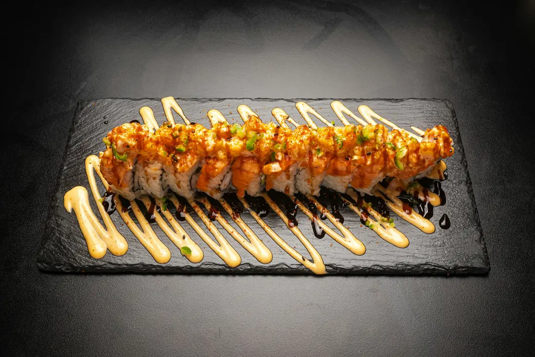 A sushi roll finished with a dark sweet glaze