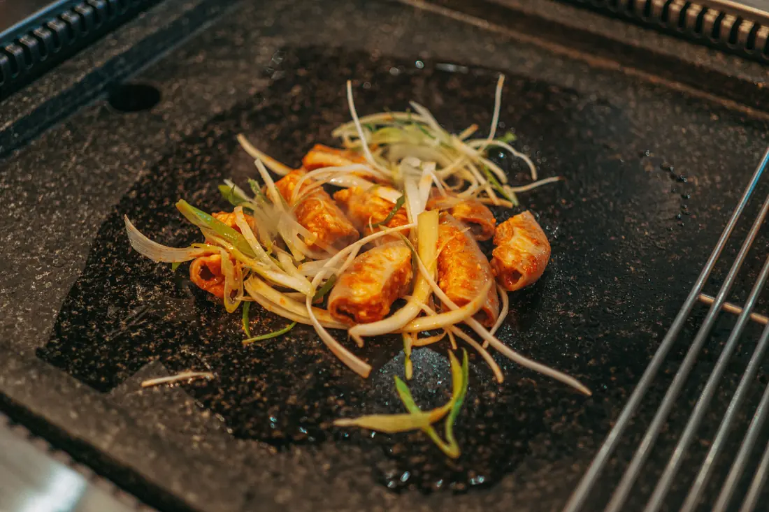 Vegetables sizzling on a hot steel cooking plate