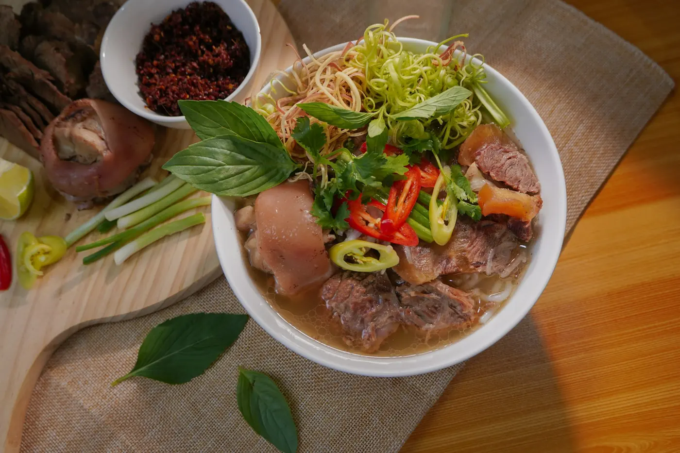 A full bowl of beef pho with herbs and noodles