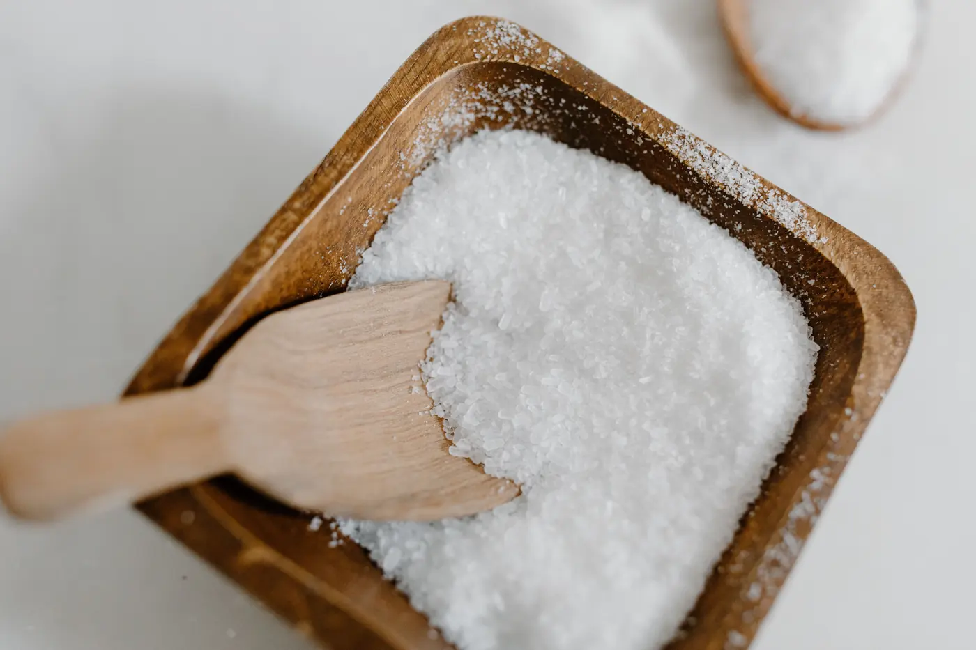 Coarse white crystals in a wooden dish