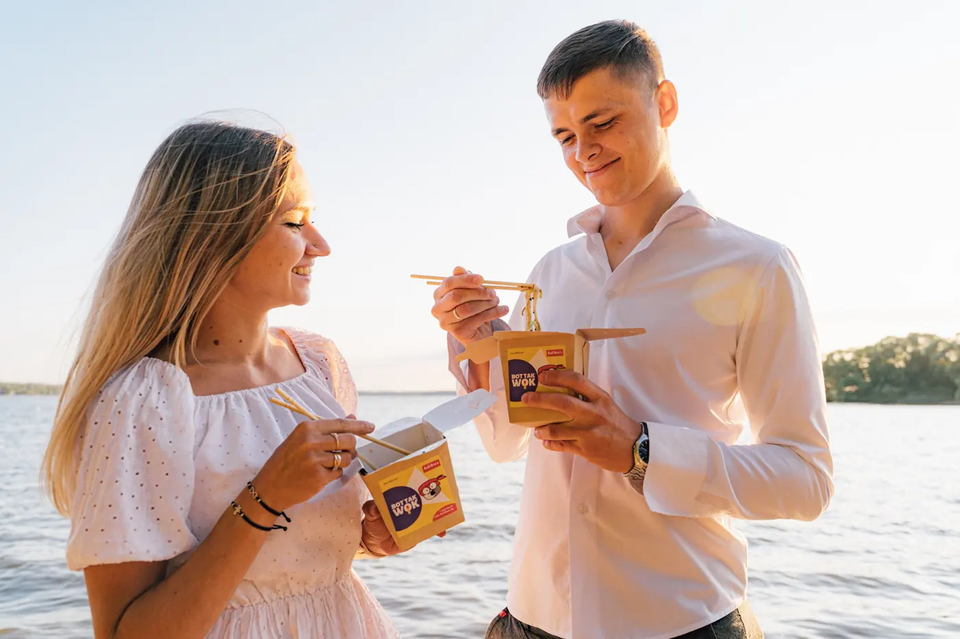 People eating from white takeaway cartons