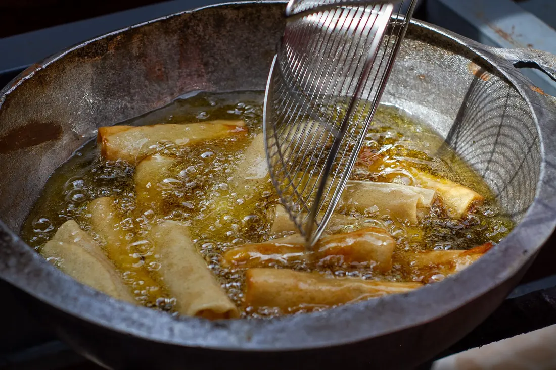 Wontons frying and turning golden in hot oil